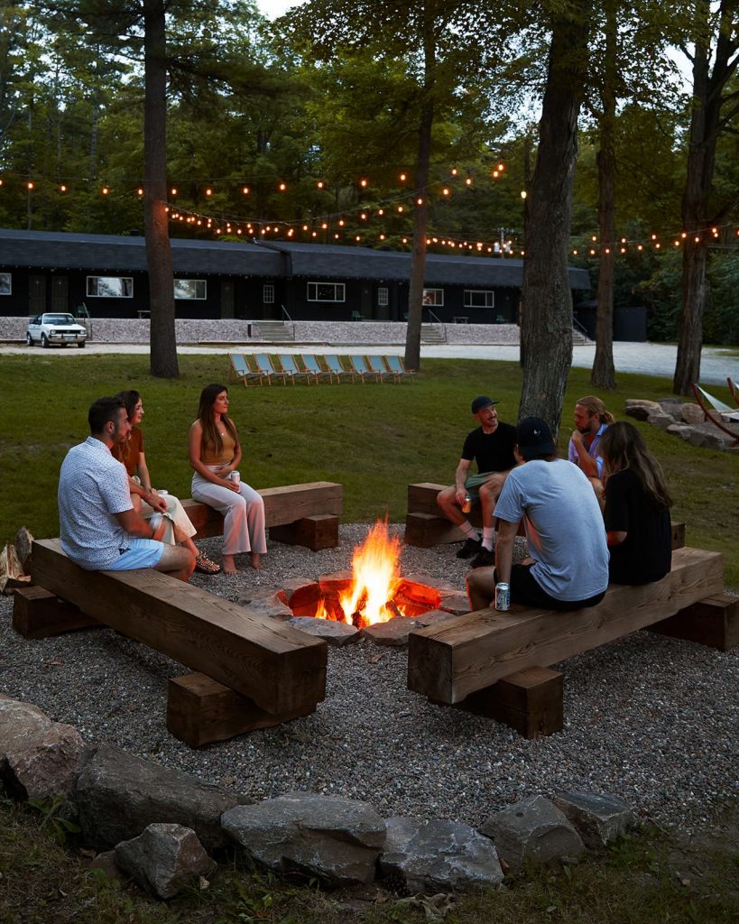 Guests congregate around a fire pit at Somewhere Inn Calabogie