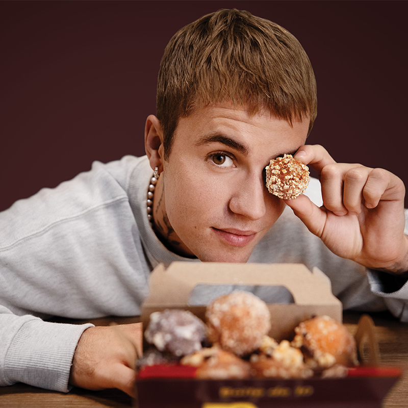 Justin Bieber posing with timbits for Tim Hortons