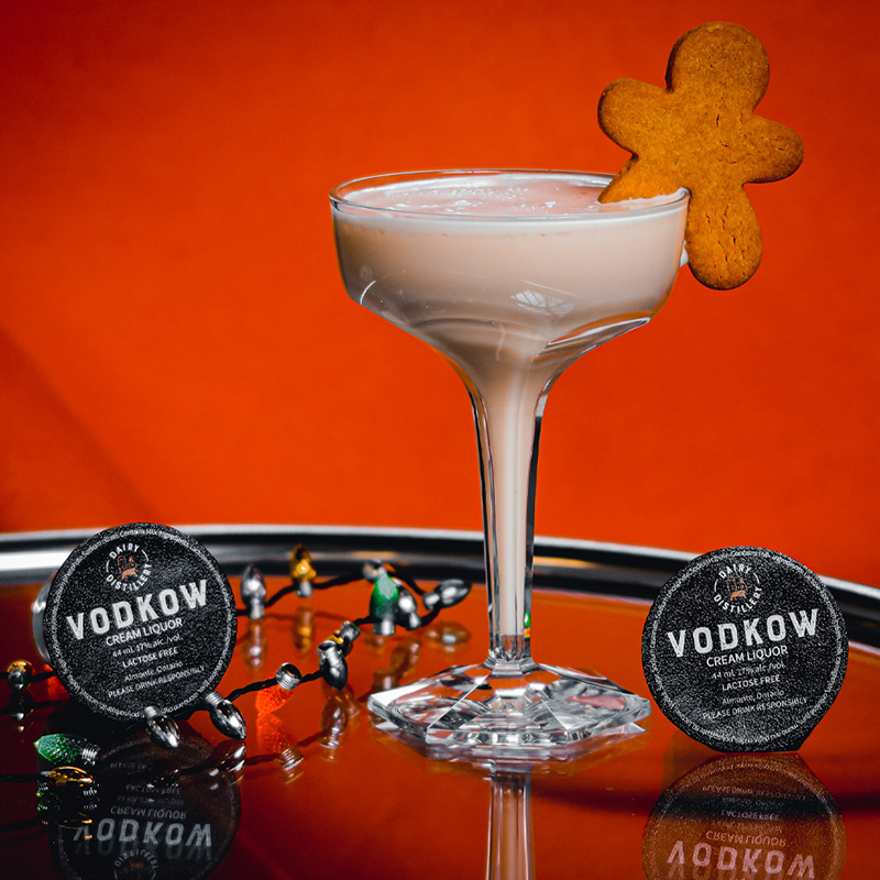 A cocktail set featuring a drink with a gingerbread in it 