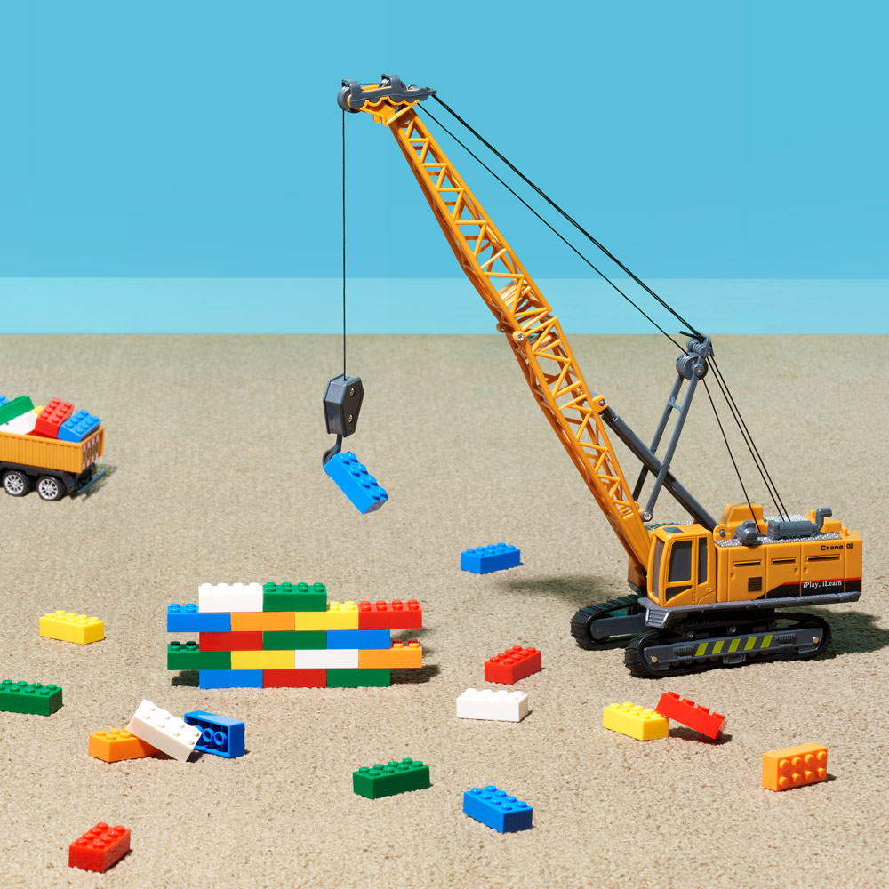 An image of a toy crane lifting lego blocks