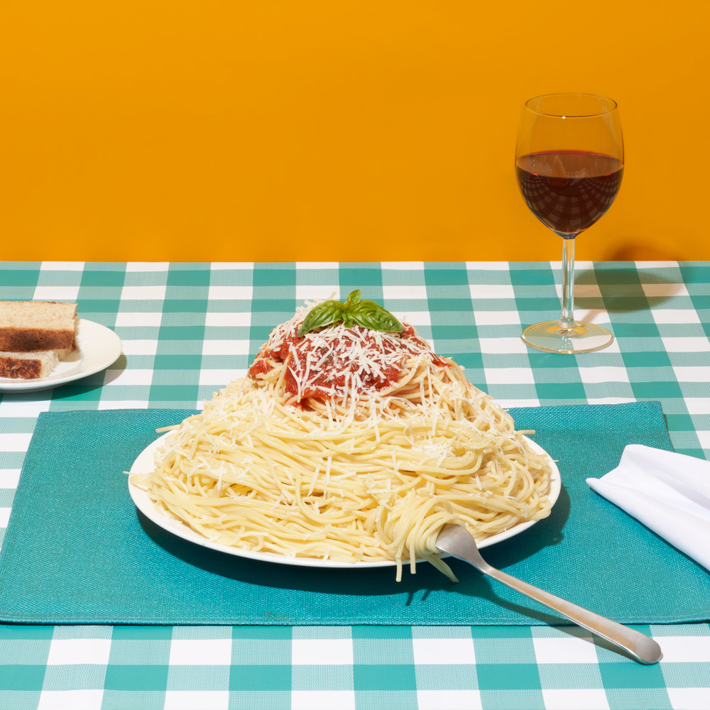 A photo of a plate of pasta on a checkered table cloth