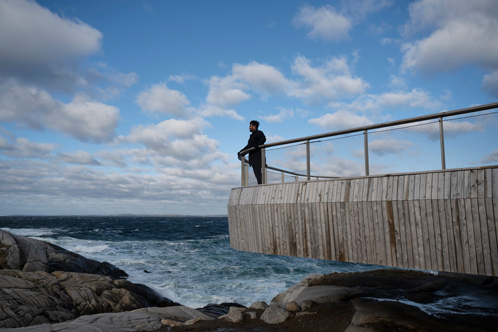 A photo of Omar Gandhi standing on the deck at Peggy's Cove