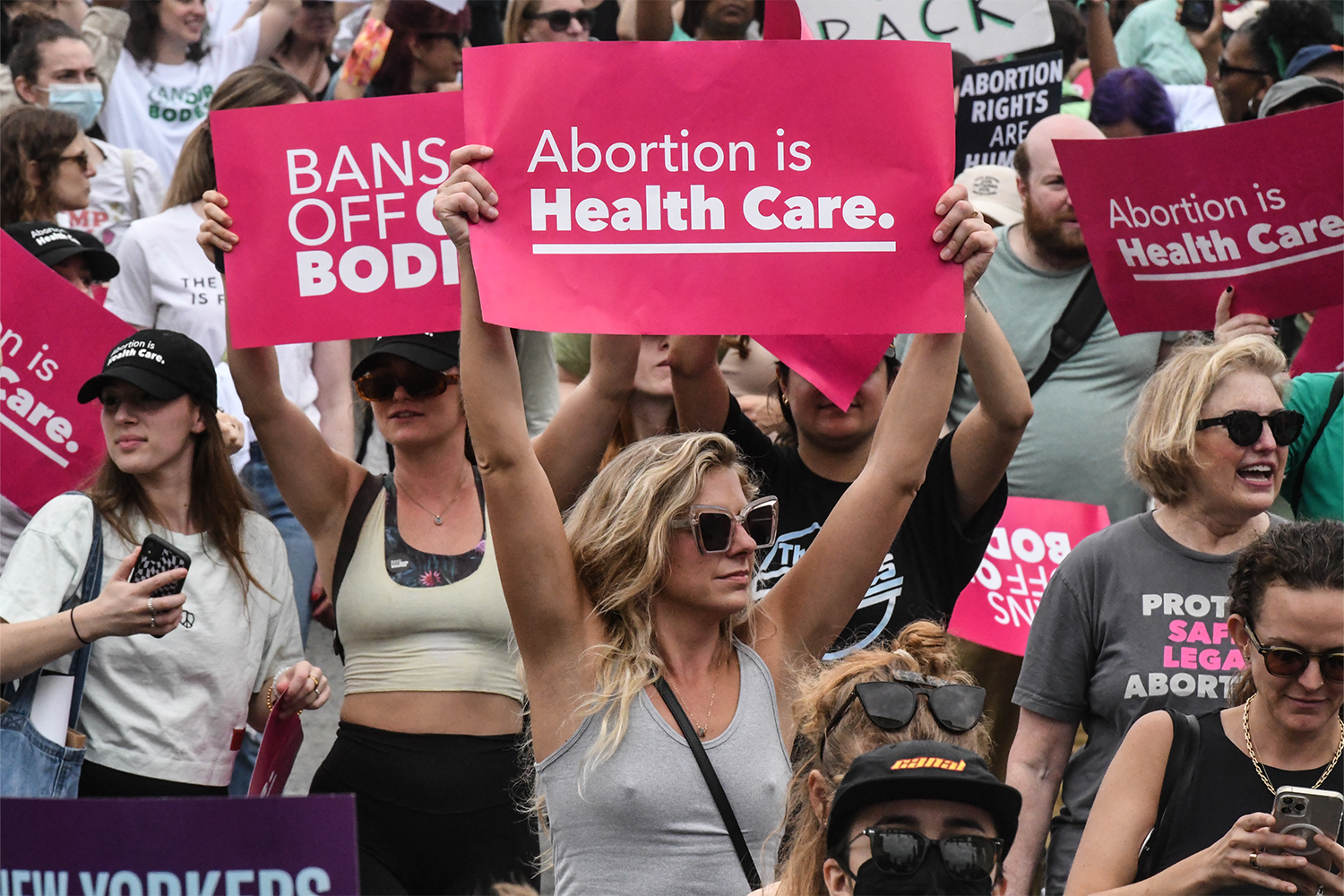 A woman holding a pro-choice sign at an abortion protest