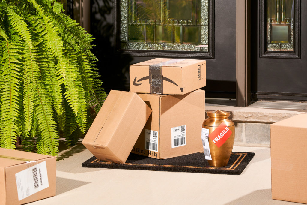 A photo of an urn and shipping boxes outside someone's front door representing funeral start-ups 