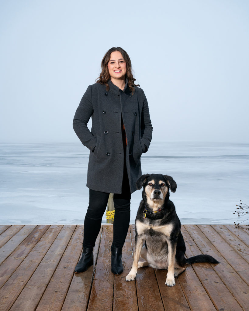 A photo of Alissa Clayton and her dog on a dock 