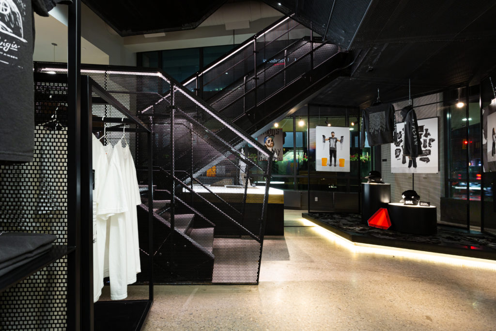 The entrance to an art gallery at the Combine displaying white T-shirts and artwork. 