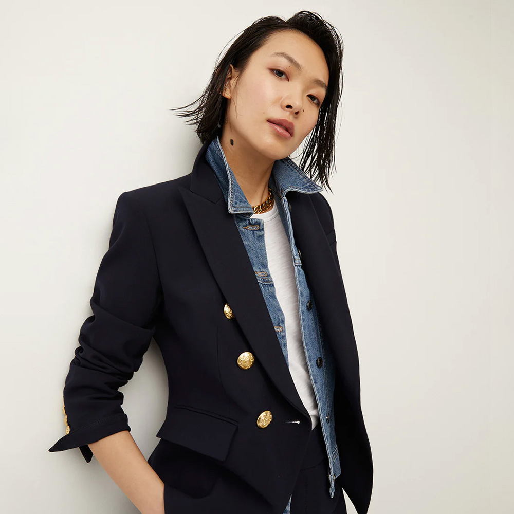 A woman wearing a black blazer on top of a white shirt and jean shirt