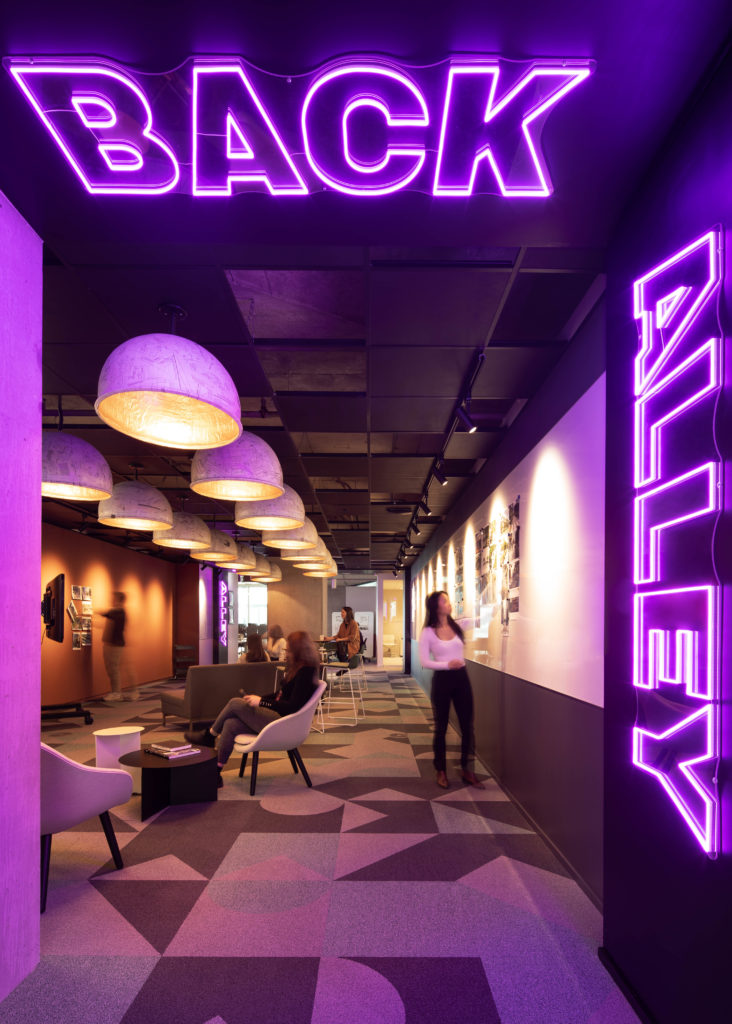 A neon sign saying Back Alley inside The Well, a Toronto workspace 