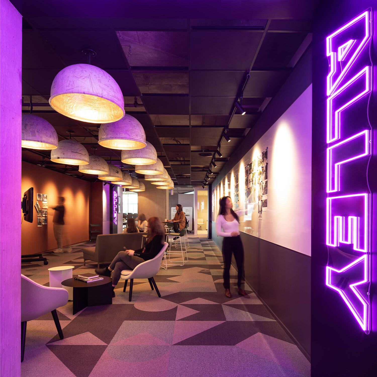 Neon purple lights inside an office building saying "Alley"