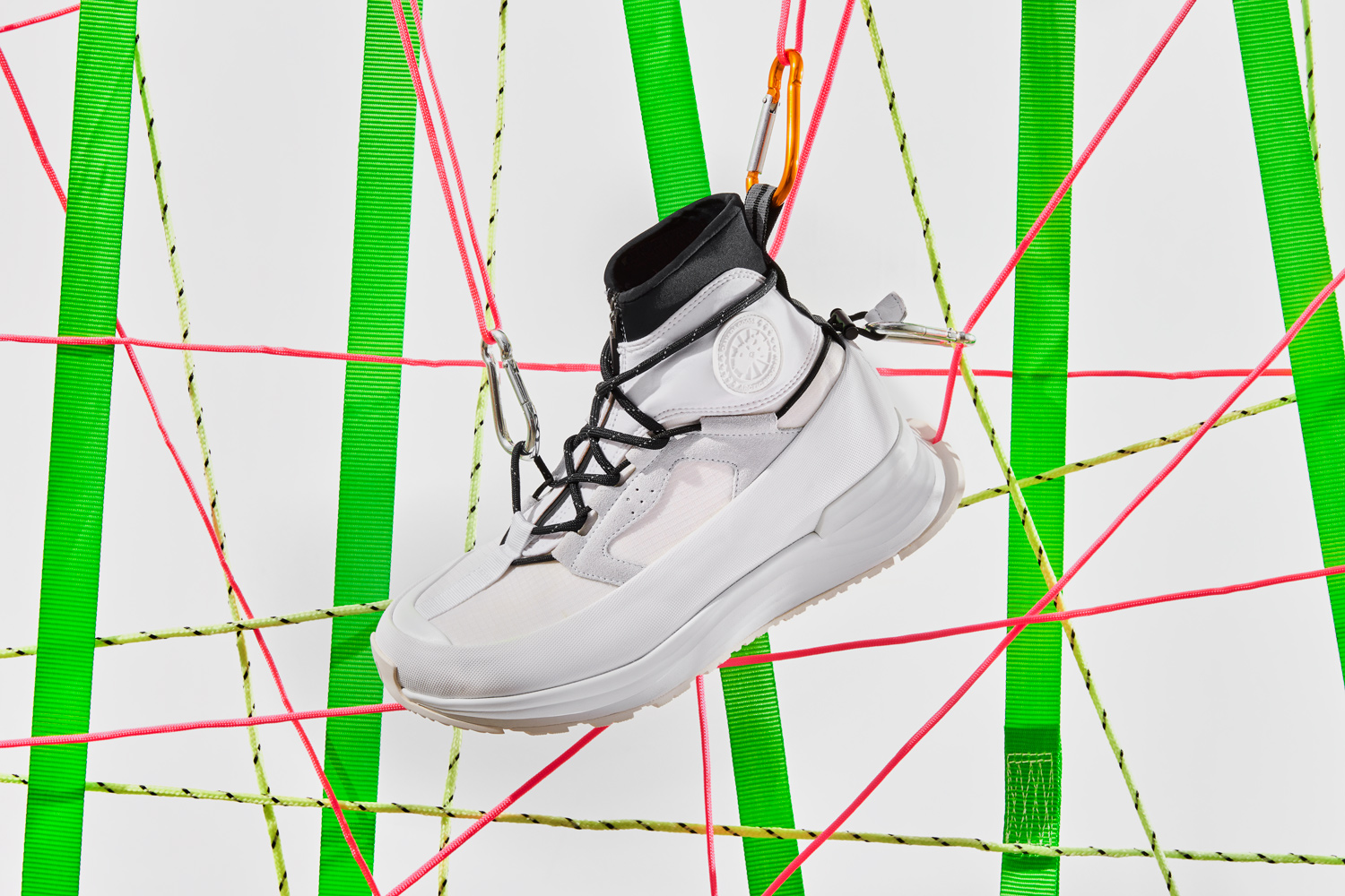 A gorpcore Canada Goose sneaker on a background made of neon coloured straps and para cords